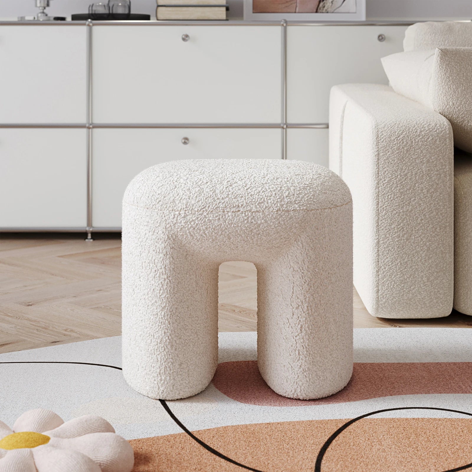 White textured stool in a modern living room setting with a neutral color palette.