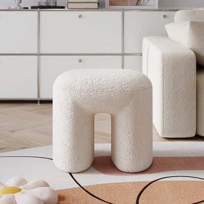 White textured stool in a modern living room setting with a neutral color palette.