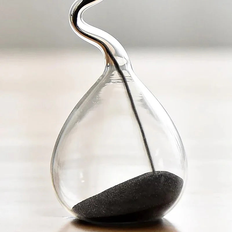 Clear hourglass with sand running through on a light background