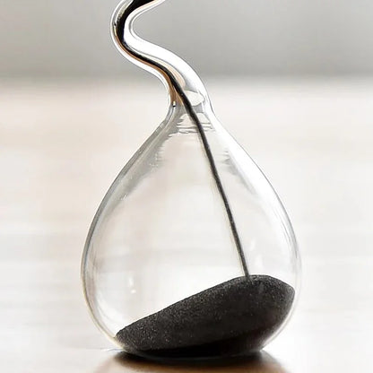 Clear hourglass with sand running through on a light background